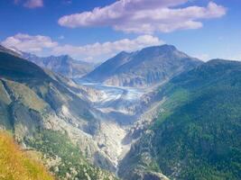a view of a valley with a glacier in the background photo