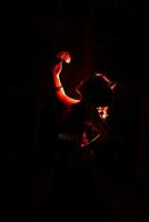 the silhouette of a female dancer holding jewelry that looks like a reflection reflecting in the dim light photo