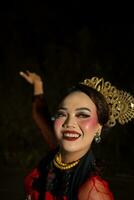 an Asian woman with makeup on her face and wearing a black shawl while dancing photo