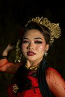 an Asian woman with makeup on her face and wearing a black shawl while dancing photo
