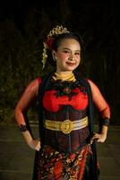 an Indonesian dancer posing with her beautiful and beautiful hands while wearing makeup at night photo