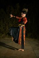 a Javanese dancer dances in front of the audience with an agile body in a black costume photo