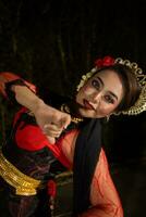 a Javanese dancer dances in front of the audience with an agile body in a black costume photo