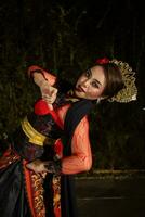 a Javanese dancer dances in front of the audience with an agile body in a black costume photo