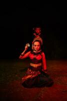 a female dancer in a red costume sat in the silence of the night which strengthened the sadness photo
