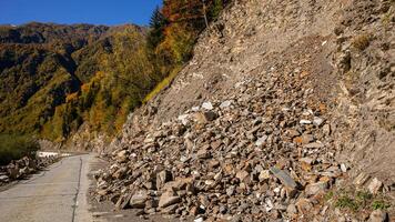 ai generado otoño deslizamiento de rocas obstruye montaña calzada foto