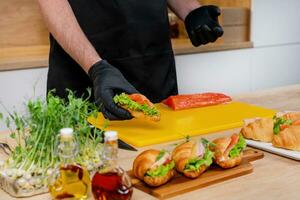 AI generated Gourmet Chef Prepares Salmon Croissant Sandwich photo