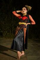 a Sundanese dancer wearing gold jewelry which gives a luxurious feel to her appearance on stage photo