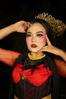 a Sundanese dancer wearing gold jewelry which gives a luxurious feel to her appearance on stage photo