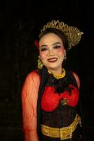 a Sundanese dancer wearing gold jewelry which gives a luxurious feel to her appearance on stage photo