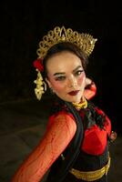 an Asian dancer amazes the audience in a cultural arts performance in red costumes photo