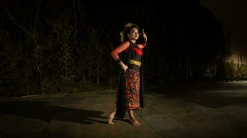 an Asian dancer dancing in front of the yard in a red costume photo