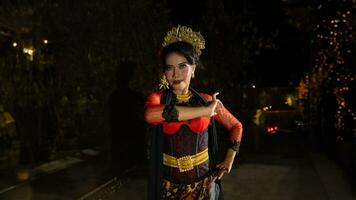 a Balinese dancer wearing gold jewelry and dancing with confidence on the stage photo