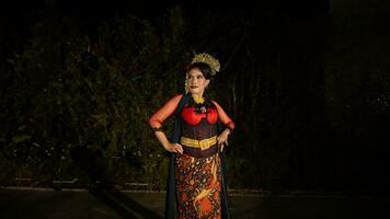 a Balinese dancer wearing a red dress with artistic details that add uniqueness to her appearance photo