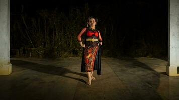 un indonesio bailarín mira lleno de entusiasmo y muestra su valor a moverse y danza foto