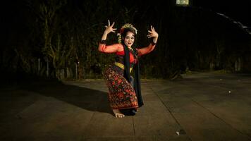 a Javanese dancer makes flexible and flowing movements in time with the rhythm of the music photo