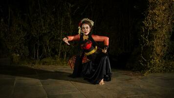 a Javanese dancer makes flexible and flowing movements in time with the rhythm of the music photo