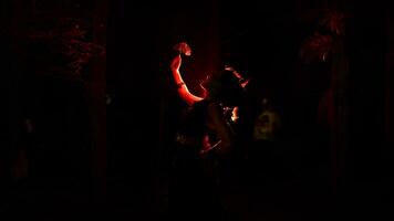 silhouette of a female dancer holding jewelry in the middle of the stillness of the night with red light photo