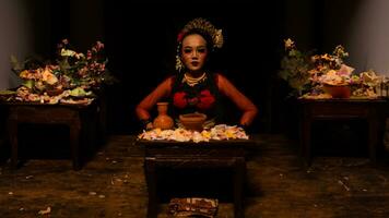 a female dancer sits gracefully and begins her ritual in front of beautiful offerings photo