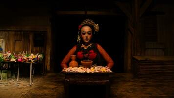 a female dancer sits gracefully and begins her ritual in front of beautiful offerings photo