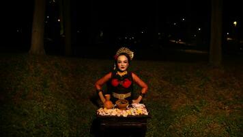 un hembra bailarín realiza un ritual ese crea un mágico y místico atmósfera en frente de flor ofrendas foto