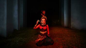 a female dancer in a red costume sat in the silence of the night which strengthened the sadness photo