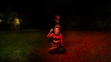 a female dancer in a red costume sat in the silence of the night which strengthened the sadness photo