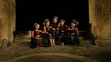 a group of dancers attract attention in striking red costumes and sit together photo