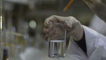 Chemist hands mixed substance of red color in test tubes. Doctor Pours red Chemicals Into In Flask. Close Up photo