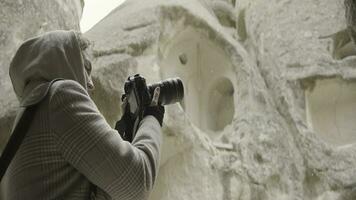 Beautiful woman takes pictures on trip with professional camera. Action. Female photographer takes pictures on camera while traveling. Attractive woman with camera for professional photos