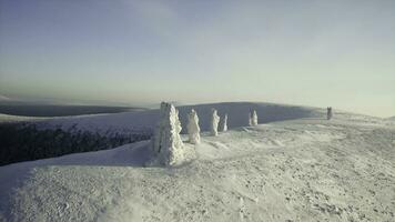 Top view of winter landscape with stone pillars. Clip. Miracle of nature on plateau with stone pillars in snow on winter day. Stone pillars in snow on background of horizon and winter mountains photo