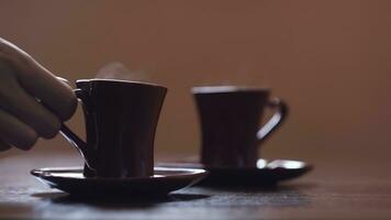 de cerca de hombre tomando taza de café. concepto. dos tazas con caliente bebida en mesa. acogedor hecho en casa tazas con caliente humeante café tazas foto