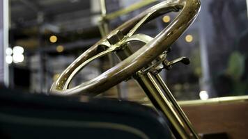 Close up of classic car details at the exhibition. Media. Retro cabriolet car and the golden steering mechanism with a wooden polished wheel. photo