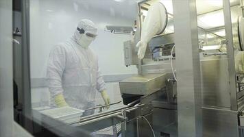 Worker in apron, cap, gloves with tablet checking process at production line in factory. Quality Control Workers Examining Pills in Lab. Pharmaceutical lab technicians inspecting the quality of photo