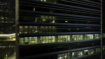 Singapore - 25 September 2018. Bright and beautiful lights reflection in night windows of business building with glass facade. Shot. Beautiful lights reflection at night, windows office building photo