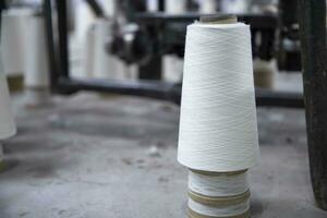 White Cotton Spools of Threads on the industrial knitting factory floor photo