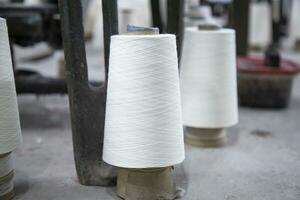 White Cotton Spools of Threads on the industrial knitting factory floor photo