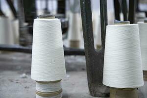 White Cotton Spools of Threads on the industrial knitting factory floor photo