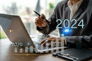 Businessman with a modern visual screen 2024 global network connection Graph analyzing financial growth and business planning concept photo