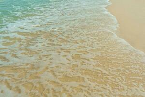 Soft wave of blue ocean on sandy beach. Summer vacation in island. clear azure water Background. photo