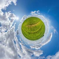 pequeño planeta verde en el cielo azul con hermosas nubes. transformación de panorama esférico 360 grados. vista aérea abstracta esférica. curvatura del espacio. foto