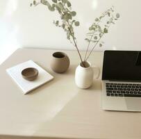 ai generado escritorio con computadora portátil, florero y lámpara en blanco mesa foto