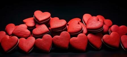 ai generado muchos rojo corazón conformado galletas en un negro antecedentes foto