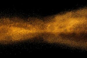 Abstract orange powder explosion isolated on black background. photo
