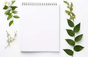 AI generated white background with empty notepad and green leaves around a white background photo