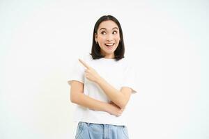 retrato de hermosa sonriente asiático mujer, señalando dedo izquierda, demostración anuncio publicitario, recomendando sitio web, aislado en blanco antecedentes foto