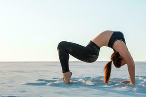 Fitness yoga woman stretching on sand. Fit female athlete doing yoga pose. photo