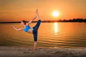 yoga a puesta de sol en el playa. foto