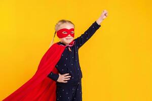 superhéroe pequeño niña en un rojo impermeable y un máscara foto