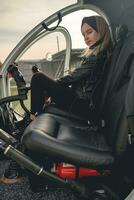 Confident tween girl sitting on co-pilot seat in helicopter cockpit photo